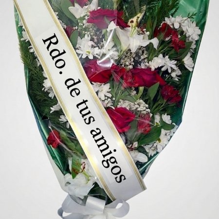 Ramo funerario elegante con rosas rojas, lirios blancos y banda de recuerdo